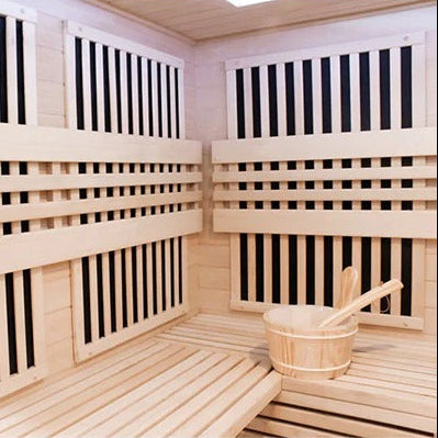 Wooden sauna interior with benches and a bucket.